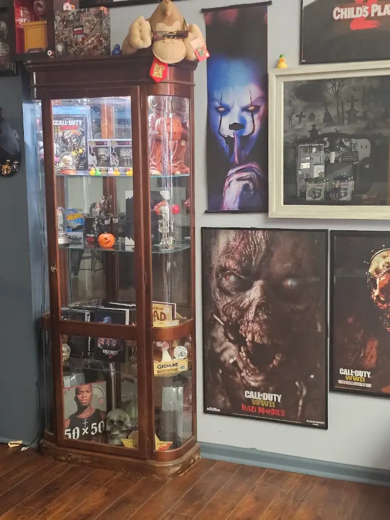 Glass display case filled with horror collectibles and memorabilia