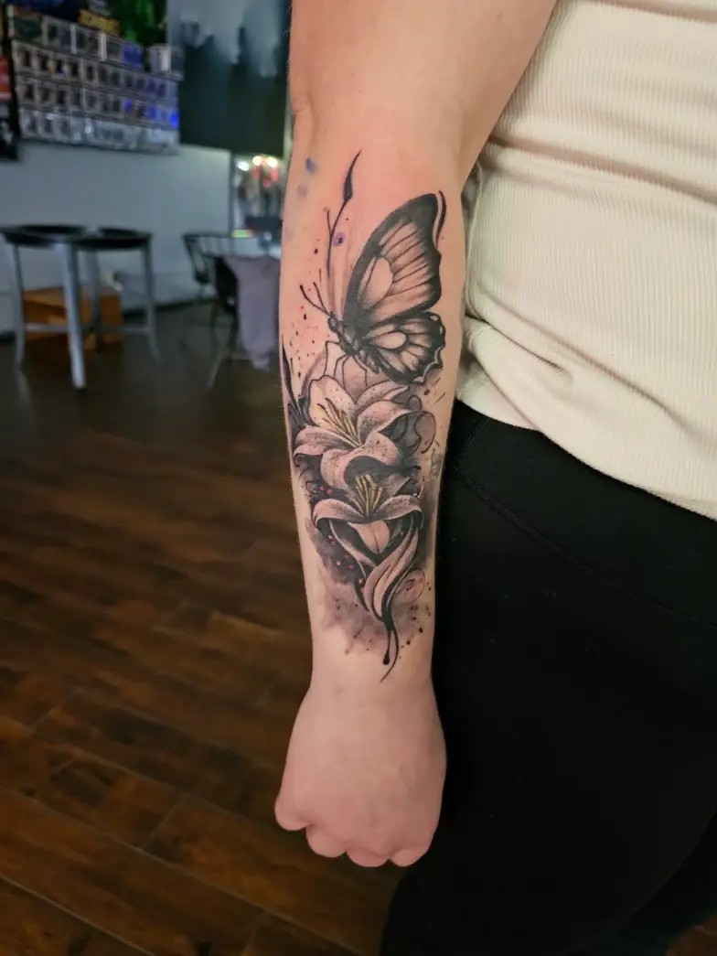 Butterfly and flower tattoo on a forearm